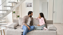 Image of a father and a daughter sitting on a couch, talking