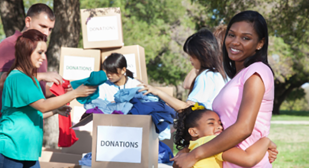 Image of a young person hugging her mother with volunteers working in the background