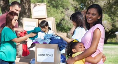 Image of a young person hugging her mother with volunteers working in the background